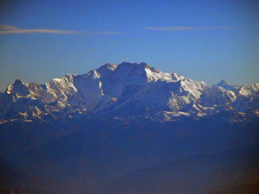 Manaslu 00 05 Kangchenjunga From Flight To Kathmandu As we waited for Kathmandu cloud cover to clear we kept circling around the Himalayas and had a very good early morning view of the sunlit south summit (8476m) of Kangchenjunga to the right of centre. To the left of the south summit are the main (8586m) and central (8482m) summits in shadow, and the sunlit west summit (Yalung Kang, 8505m) on the left. On the far left is Jannu (7111m).